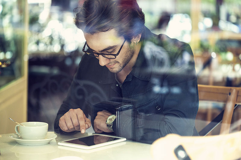 A client reviewing his finances on a tablet in a café